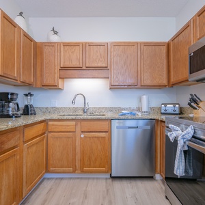 Cook and gather in the inviting kitchen with granite countertops and white appliances, perfect for meal preparation