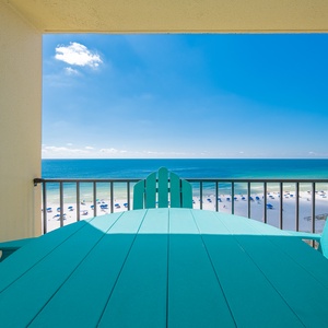 Enjoy breathtaking views from the turquoise patio furniture overlooking the serene beach and vibrant blue waters