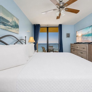 Plush king bed embraces you in this master suite as the coastal breeze hums softly beyond the balcony doors