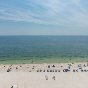 This breathtaking beach view showcases vibrant umbrellas on the soft sand and various water activities