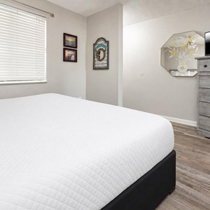 Cozy bedroom featuring a comfortable king bed, a TV, and charming decor with framed artwork, creating a welcoming atmosphere