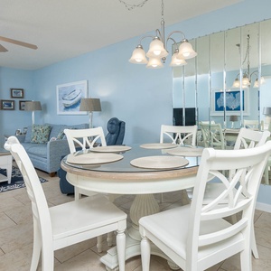 Dine comfortably at the round table, surrounded by coastal decor and inviting seating in a relaxing atmosphere