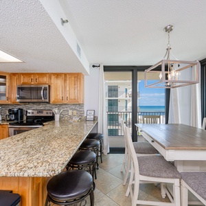 Gather around the dining table or breakfast bar, enjoying the inviting space with views of the water beyond
