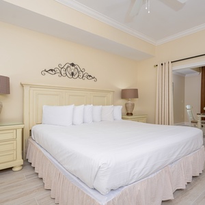 Bright and inviting master bedroom featuring a king bed, stylish decor, and a lovely view of the dining area and balcony