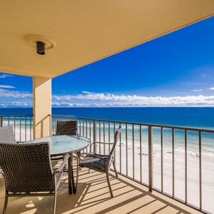 Enjoy breathtaking views from the balcony, featuring a glass table and comfortable seating overlooking the serene beach