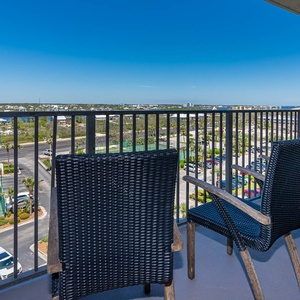 Balcony with seating off the master offers views of the nearby tennis courts and vibrant surroundings, perfect for relaxation