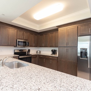 Prepare meals in this inviting kitchen with stainless appliances, sleek cabinets, and spacious counters