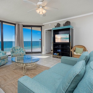 Relax in the inviting living area with a view of the beach, featuring comfortable seating and a TV for entertainment