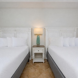 Drift into a restful sleep on soft queen bedding with warm coastal vibes in this inviting guest bedroom