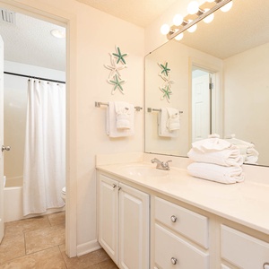 Refresh in the master bathroom featuring a spacious vanity, decorative accents, and a relaxing tub-shower combination