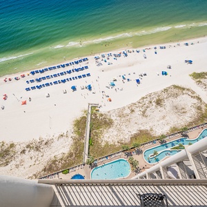 Astonishing view of the beach, pool area, lazy river, and vibrant beach umbrellas from this stunning balcony perspective