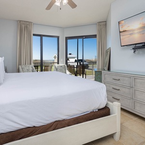 Relax in the serene master bedroom featuring a comfortable king bed, stylish decor, and large patio windows