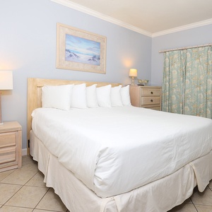 This bedroom features a comfortable white bed, soft blue walls, and charming decor, creating a serene retreat for guests