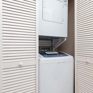 The laundry area features a stacked washer and dryer, providing convenience for guests during their stay