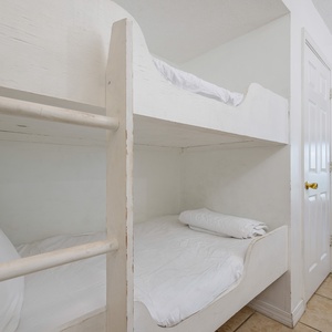 This cozy space features a bunk bed and a view of the beach, with a bright living area just steps away