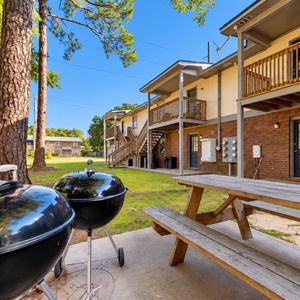 Relax in the shaded outdoor area with picnic tables and grills, perfect for gatherings and enjoying meals al fresco
