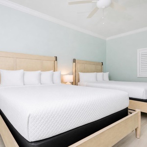 Tranquil bedroom for guests featuring two queen beds, soft linens, and a soothing coastal color palette