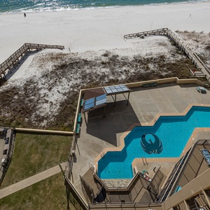 Enjoy the inviting pool area with vibrant lounge chairs and a scenic view of the pristine beach just steps away