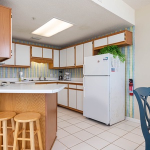 Cook meals in the functional kitchen, featuring ample counter space, wooden cabinets, and a cozy dining area