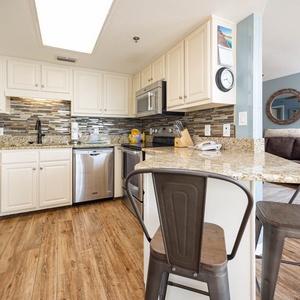 Bright kitchen featuring granite countertops, modern cabinetry, and a breakfast bar with stylish seating for casual dining