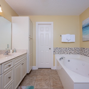 Indulge in a soothing soak in the jetted tub in the master, surrounded by serene decor, for a soothing beach retreat