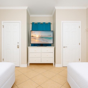Enjoy cozy movie nights on the double beds while making lasting memories with family in this guest bedroom