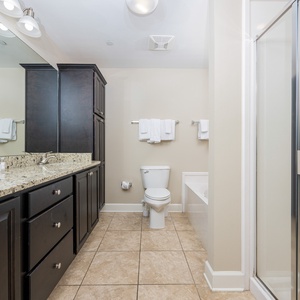 Spacious master bathroom with a granite countertop, relaxing walk-in shower, and jetted tub