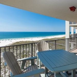 Inviting balcony with a table and chairs offers a direct view of the beautiful beach and tranquil gulf waters