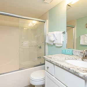 Refresh in this guest bathroom featuring a spacious countertop, soft towels, and cheerful coastal accents