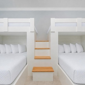 Experience cozy sleeping arrangements in this bunk room with two lofted twin beds above two queens