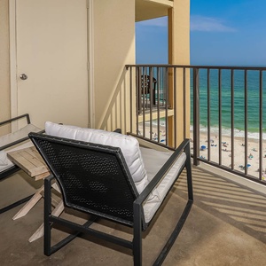 Relax on the balcony with comfortable seating and enjoy the beautiful beach view just steps away
