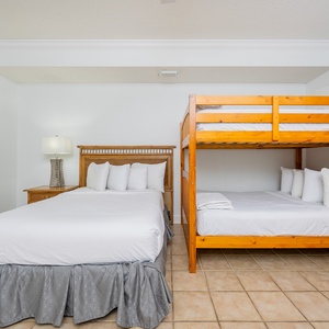 Relax after a fun vacation day on the queen bed, perfect for family stays, featuring a bunk with two doubles