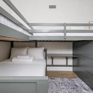 Sleep comfortably in this charming room featuring two twin bunk beds and a cozy lower double bed