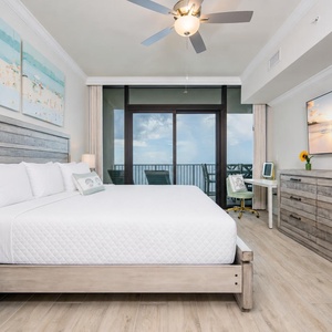 Relax in the master bedroom featuring a king bed, stylish decor, and a lovely view from your beachfront balcony