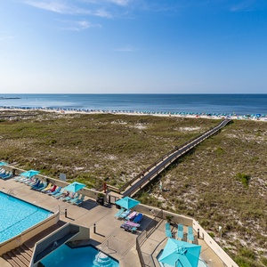 Watch the sunlight shimmer on the pool's surface as you hear distant laughter near the coast