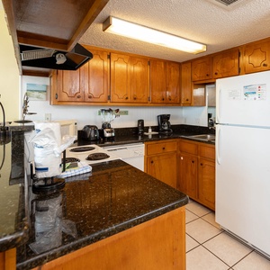 The kitchen features wooden cabinetry, sleek countertops, and essential appliances for a delightful cooking experience