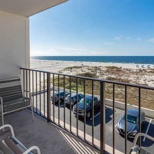 Enjoy a relaxing view from the balcony with seating, overlooking the beach and vibrant blue waters