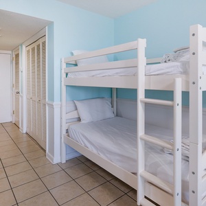Brightly colored living space featuring a white twin bunk bed, perfect for kids, with a welcoming beachy vibe