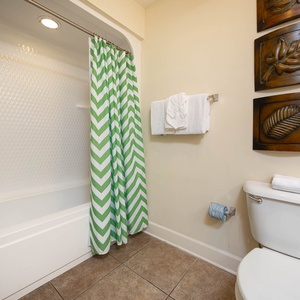 Unwind in the relaxing tub in this guest bath, enjoying fresh towels nearby for added comfort after a day of beach fun