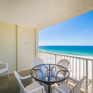 Enjoy stunning beachfront views from this balcony, featuring a cozy table and chairs for relaxing moments