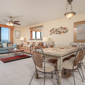 Bright living area features a cozy sofas with a queen sleeper, decorative accents, and a dining table with stylish chairs