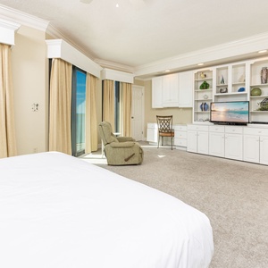 Elegant master bedroom on the beach with a king bed, cozy seating, and large windows offering beautiful views