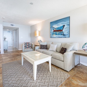 Unwind in the spacious living area, featuring a queen sleeper sofa, a decorative fish sculpture, and vibrant artwork