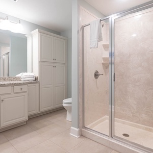 Enjoy a relaxing shower after a day at the beach in this guest bath with stylish accents and fluffy towels
