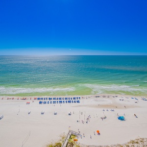 Pristine white-sand beach and vibrant umbrellas under a clear blue sky, perfect for a relaxing getaway