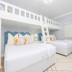 Cheerful guest bedroom featuring two queen beds, a cozy loft with two twins, and playful decor