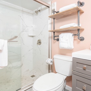 Refresh with a revitalizing walk-in shower in this stylish master bath, surrounded by plush towels and cheerful colors