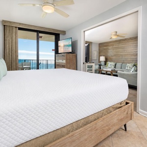 Cozy master suite featuring a plush king bed, TV, and beachfront balcony access