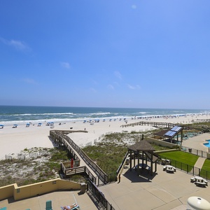 Enjoy the stunning views of the serene beach and inviting pool area from this relaxing outdoor space