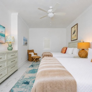 Plush blankets invite restful nights in the guest suite with two queen beds and colorful pillow accents